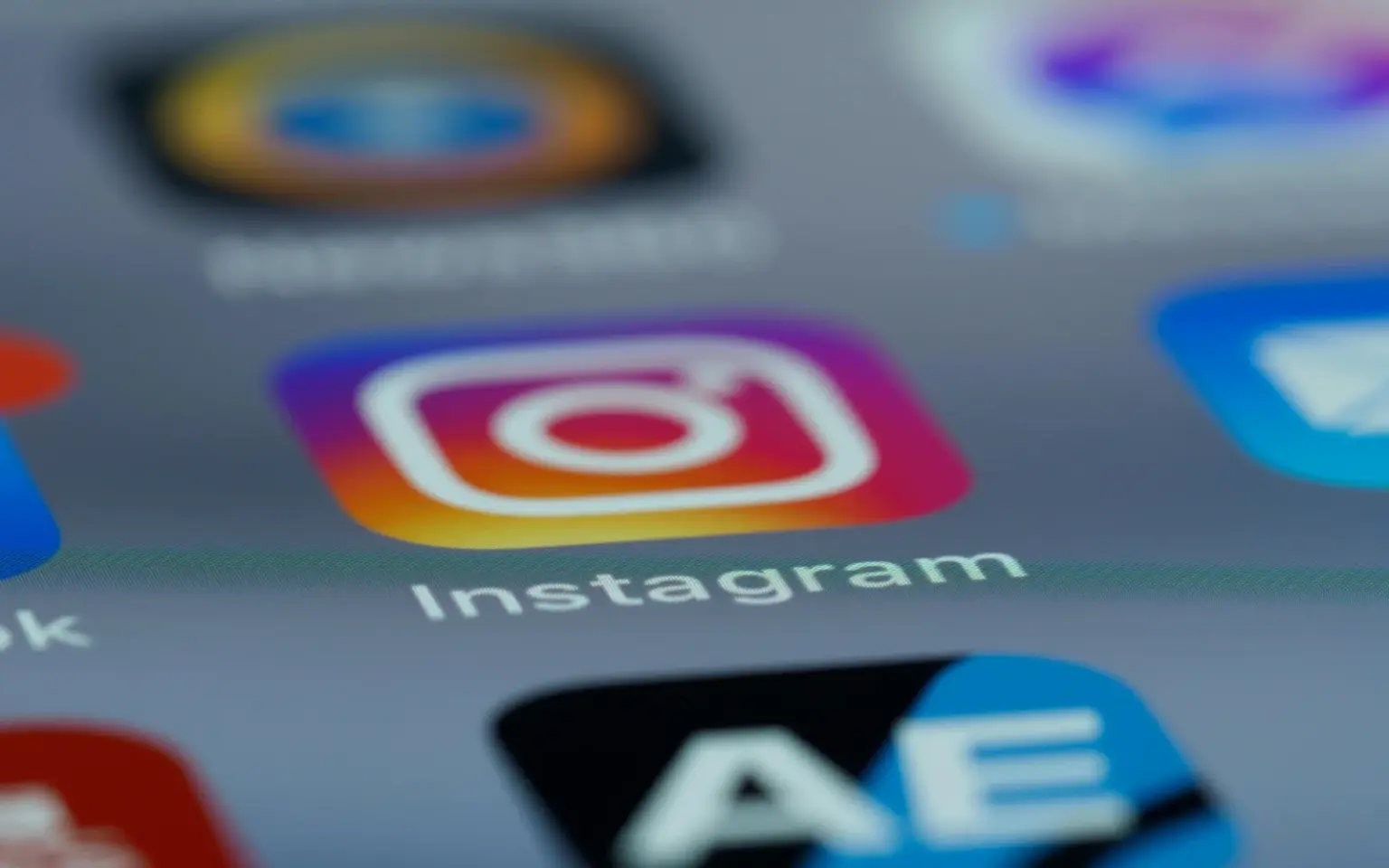 Primissimo piano dello schermo di uno smartphone che mostra le icone delle app con al centro quella di Instagram
