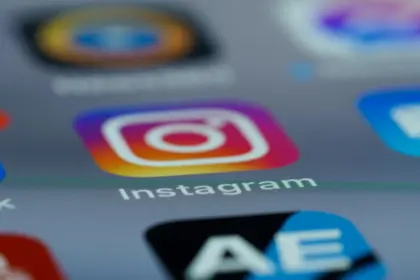 Primissimo piano dello schermo di uno smartphone che mostra le icone delle app con al centro quella di Instagram