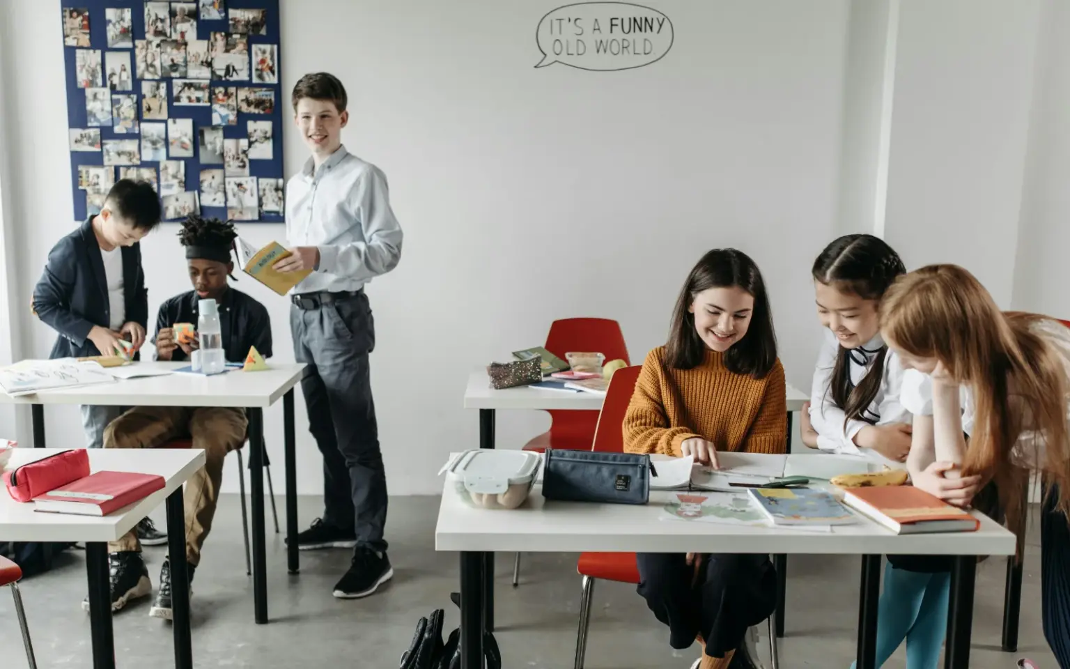 Immagine di una classe scolastica con bambini impegnati a giocare in piccoli gruppi.