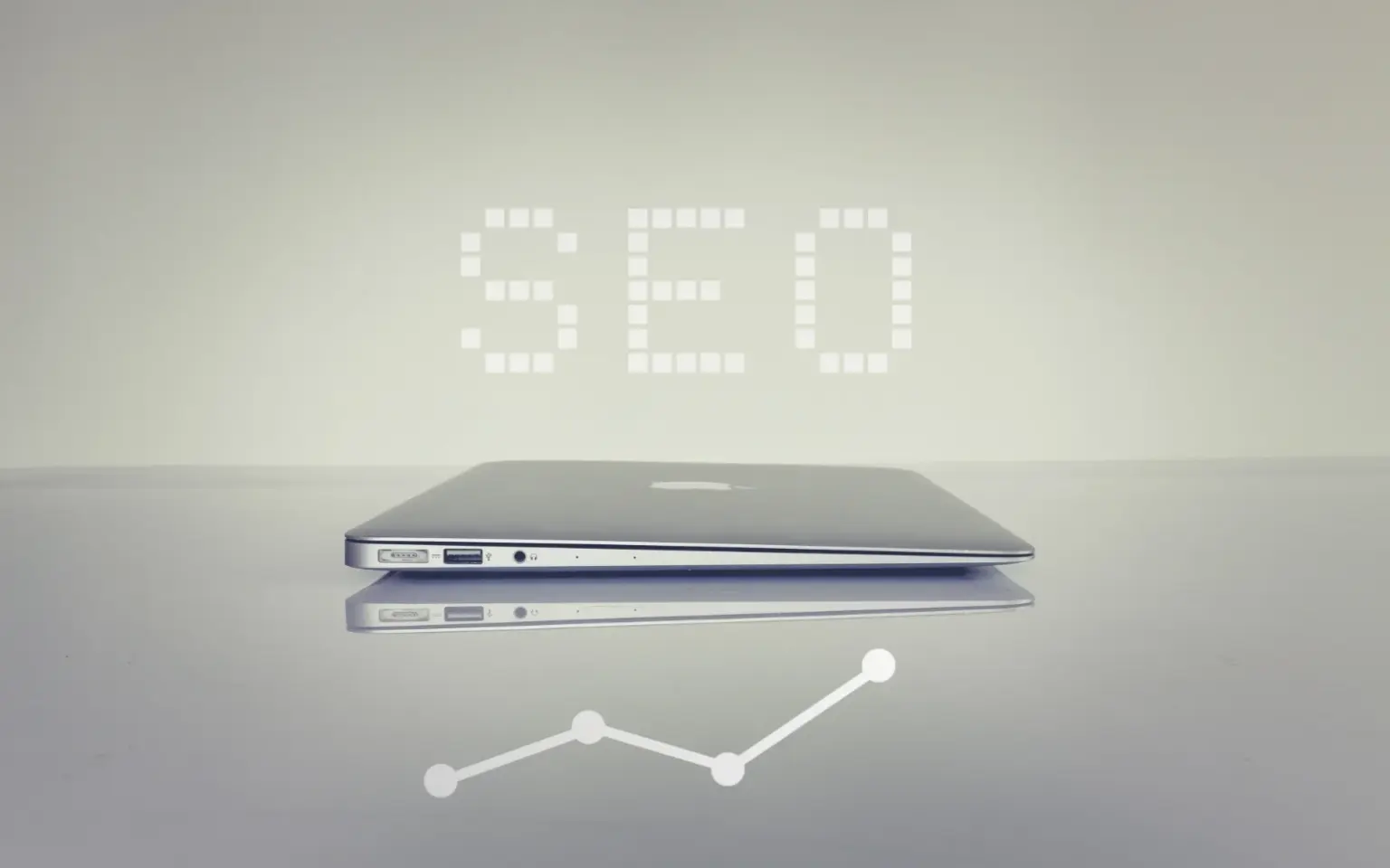 Immagine di un computer portatile chiuso e visto di lavo. Sopra il computer si legge la scritta SEO.