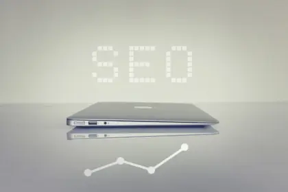 Immagine di un computer portatile chiuso e visto di lavo. Sopra il computer si legge la scritta SEO.