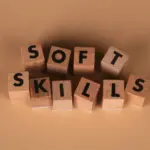 Cubi di legno visti dall'alto con lettere incise nel legno che formano la dicitura "Soft Skills"