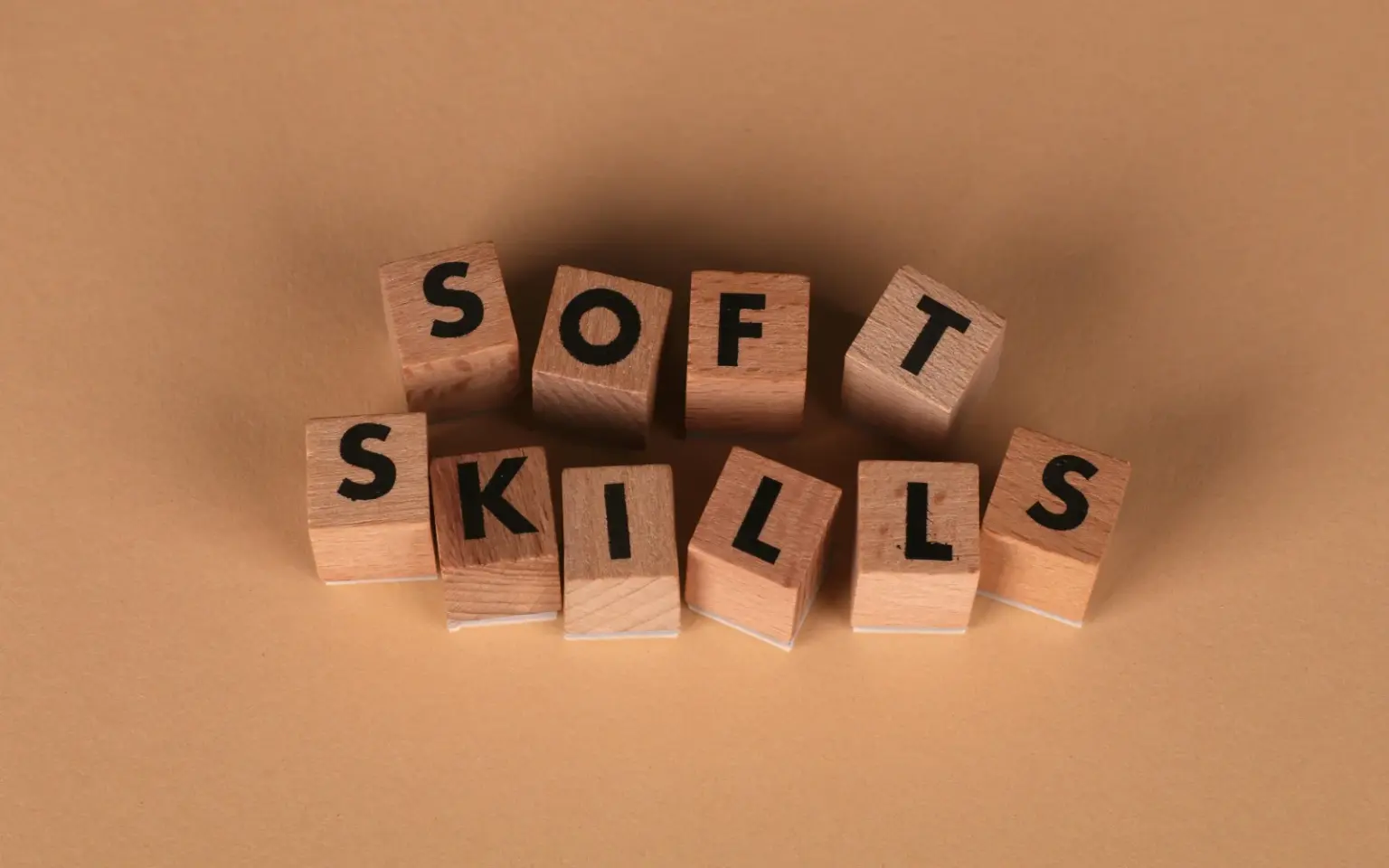 Cubi di legno visti dall'alto con lettere incise nel legno che formano la dicitura "Soft Skills"