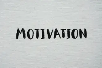 Scritta "Motivation" scritta a mano con un pennello a tempera nera su una tela canvas bianca