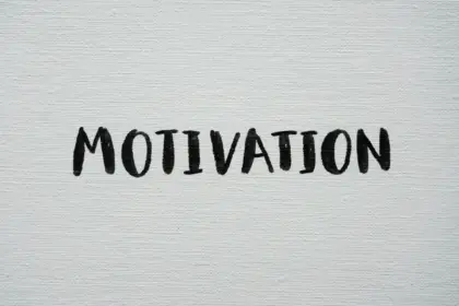 Scritta "Motivation" scritta a mano con un pennello a tempera nera su una tela canvas bianca